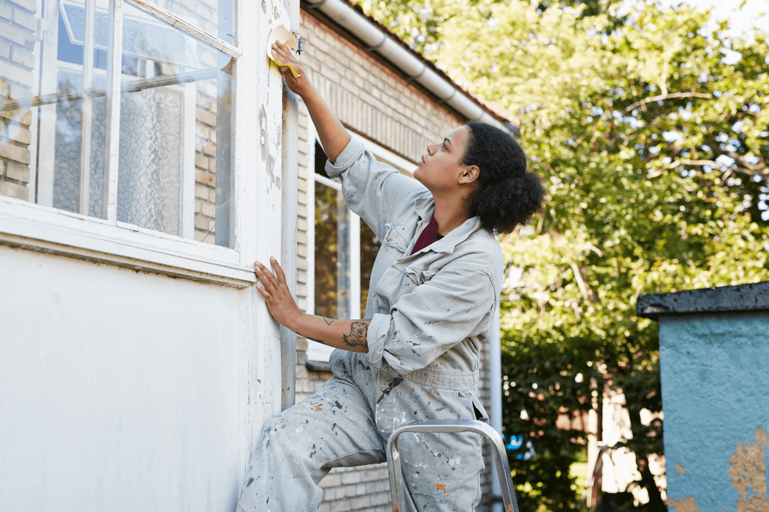 Young woman working on the exterior of a house