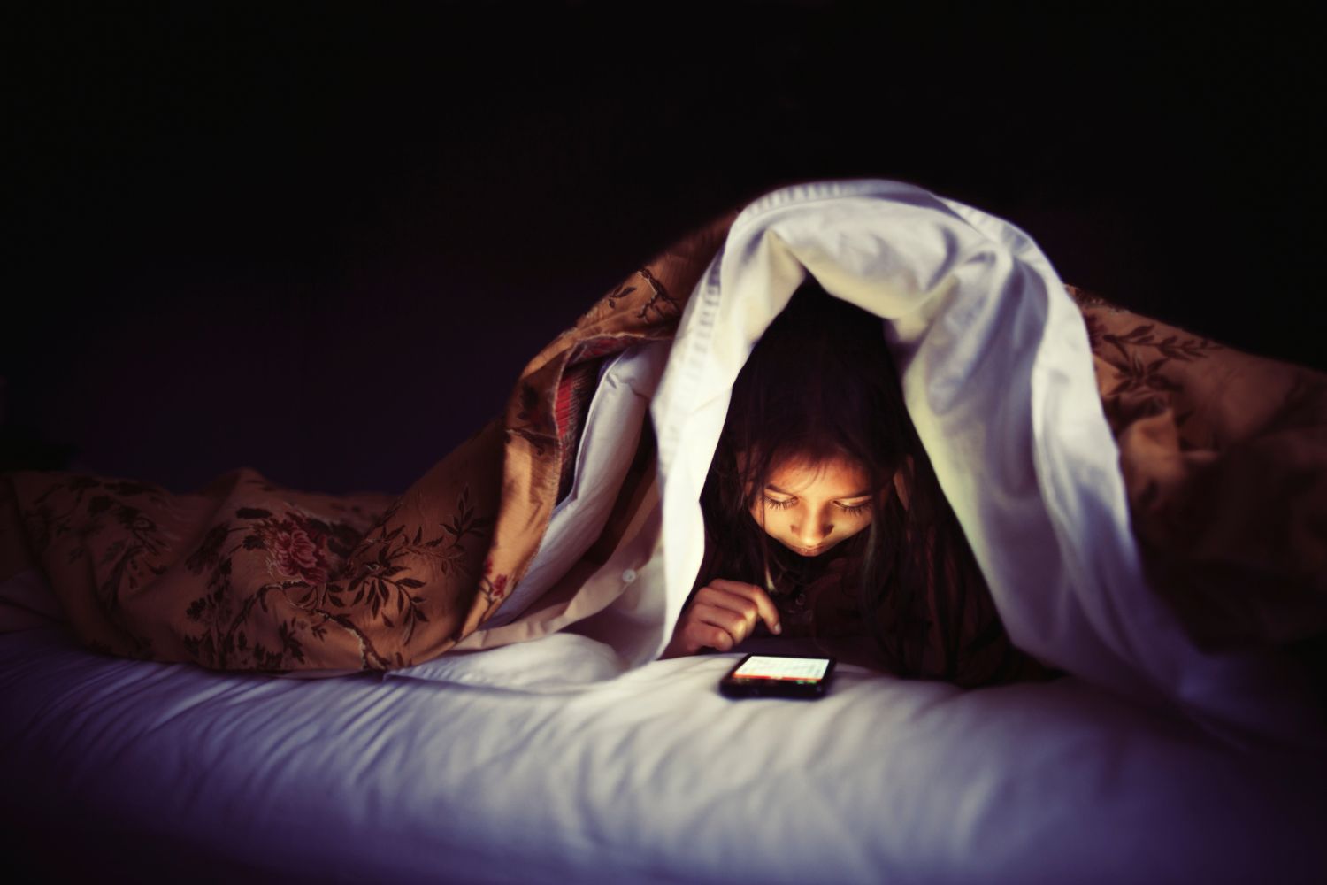 person-on-phone-in-bed