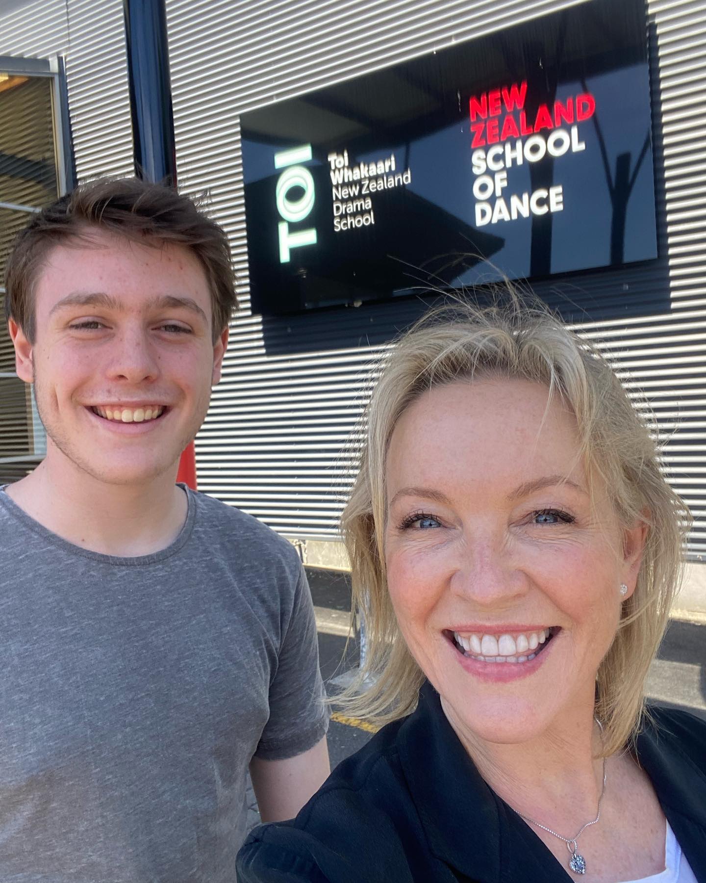 Actress Rebecca Gibney and teenage son stand in front of building