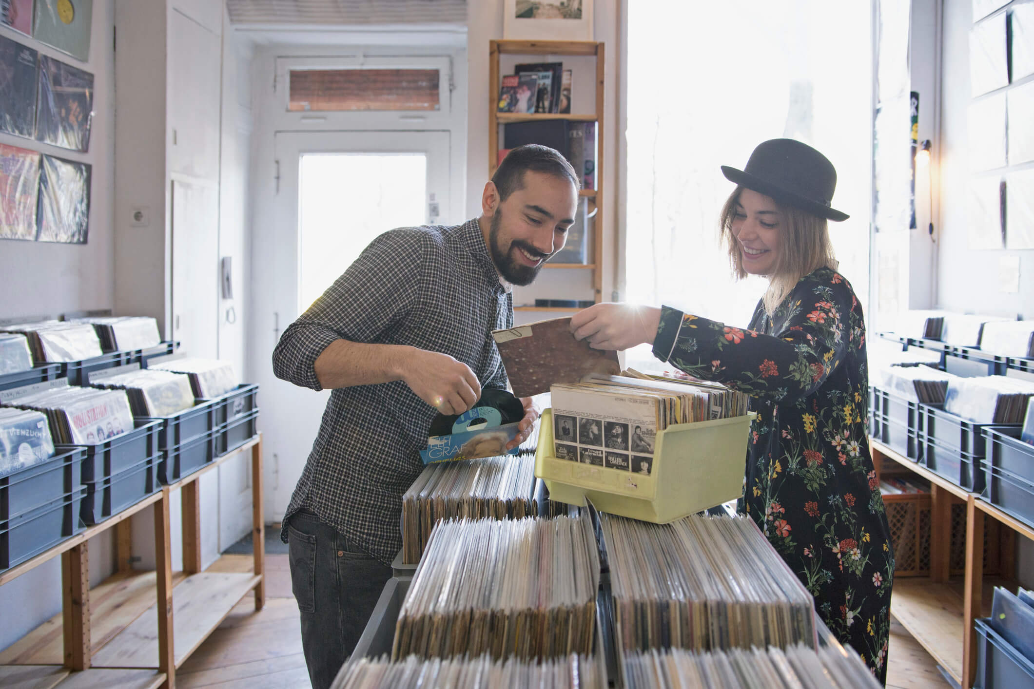 A girl showing a guy a vinyl at a music store
