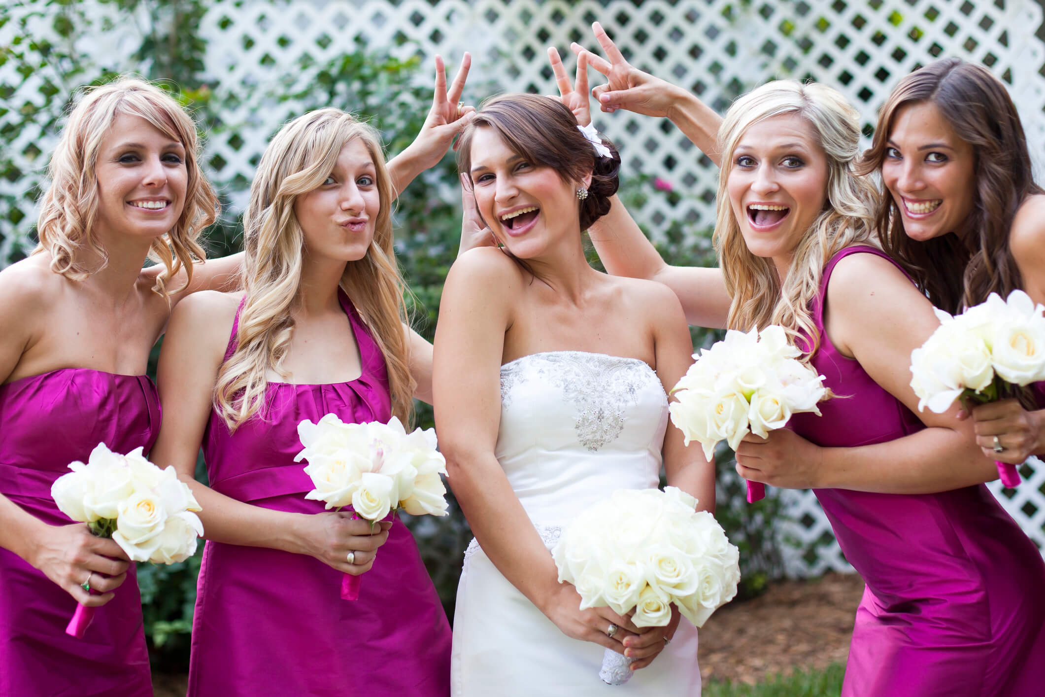 Bride surrounded by bridesmaids in pink dresses