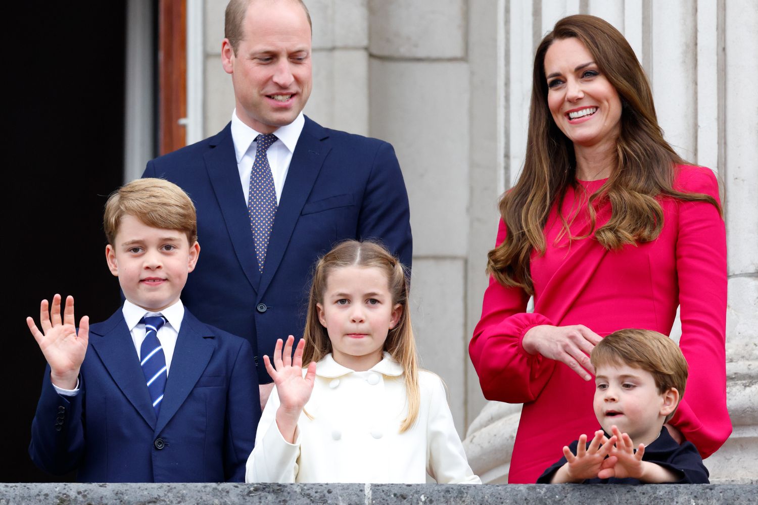 A family standing together on a balcony, some waving, dressed in formal wear.