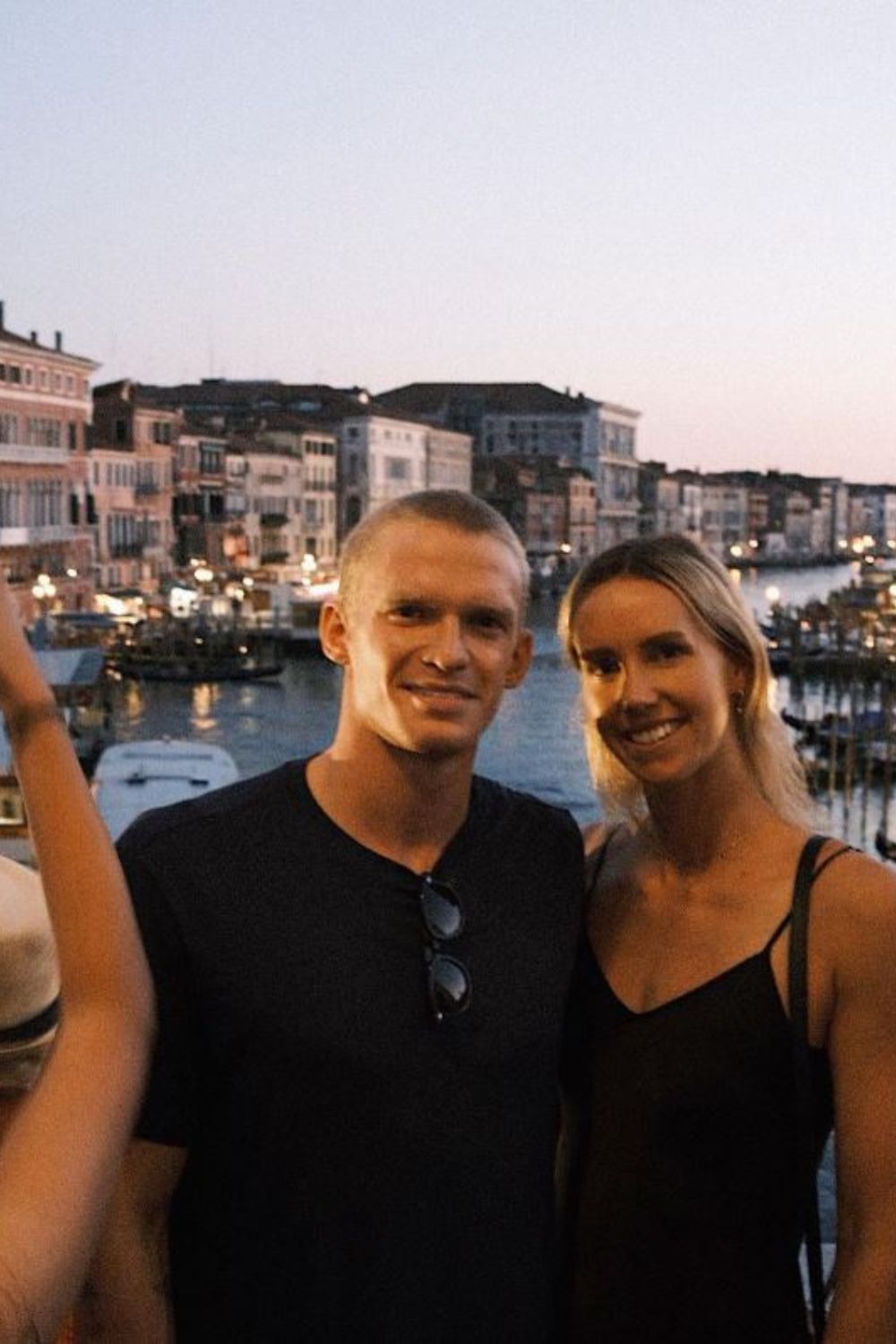 Couple smiling at the camera with a canal view in the background.