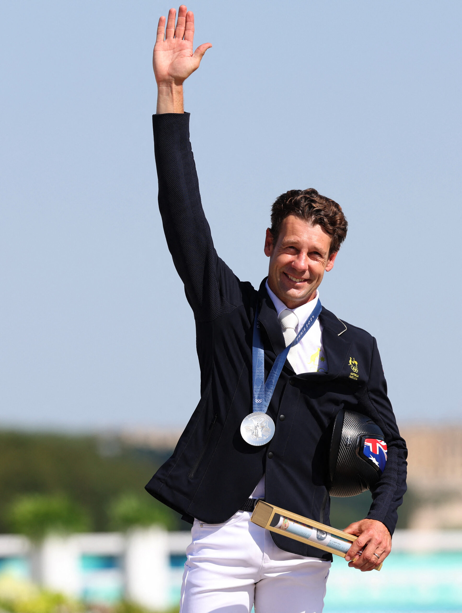 Christopher Burton celebrates his silver medal on the podium during the victory ceremony of the equestrian individual jumping